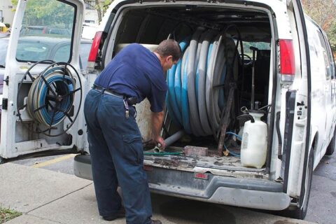 man removing pipe from the van