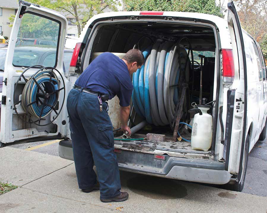 man removing pipe from the van