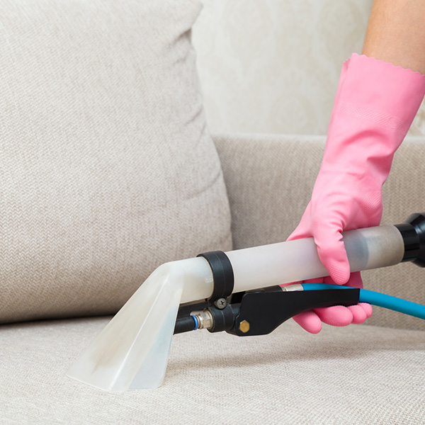 Woman hand in rubber protective glove using spray nozzle of professional vacuum cleaner