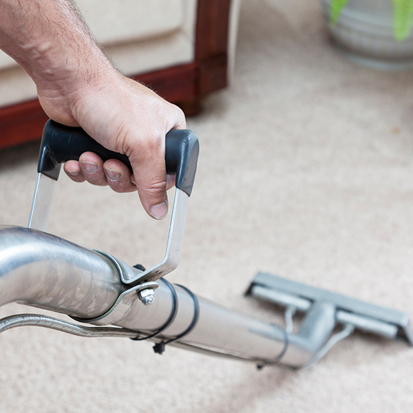 Man cleaning carpets in home